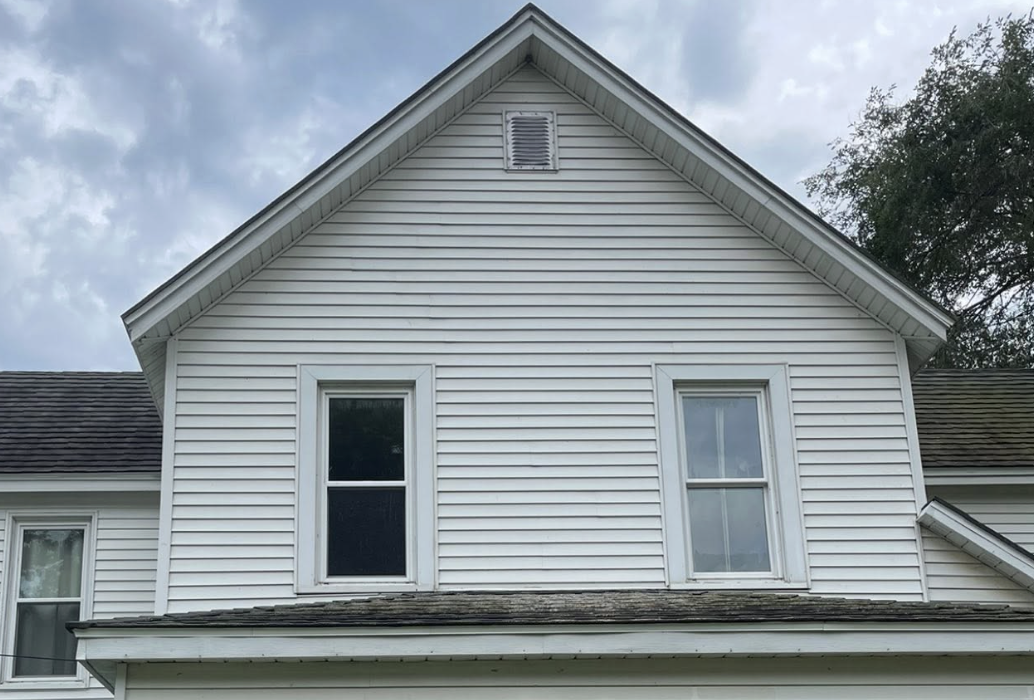 The same white house siding clean after soft washing